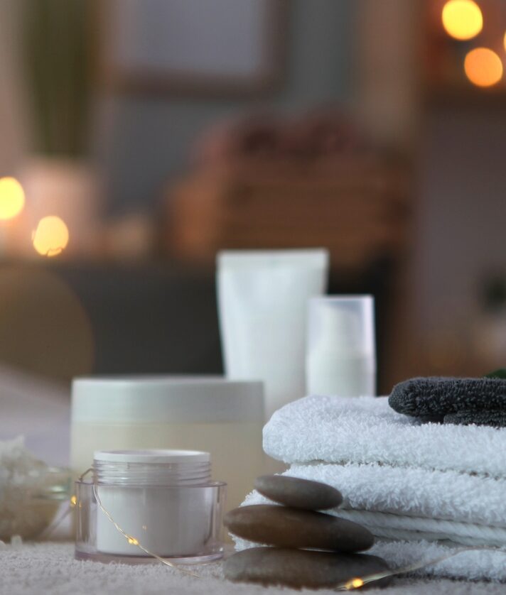 Various spa accessories on a massage bed with candles lit