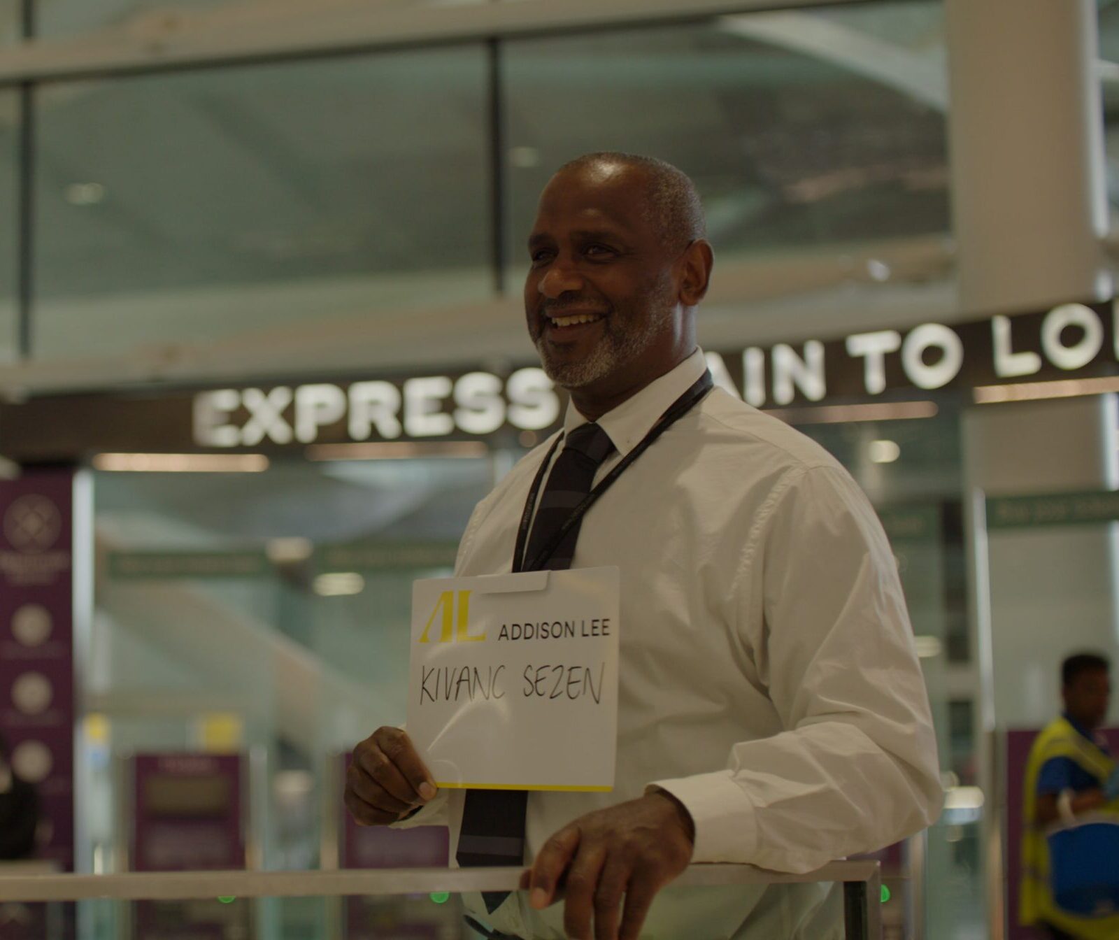 Addison Lee driver waiting at the airport arrivals lounge with a name board for their passenger