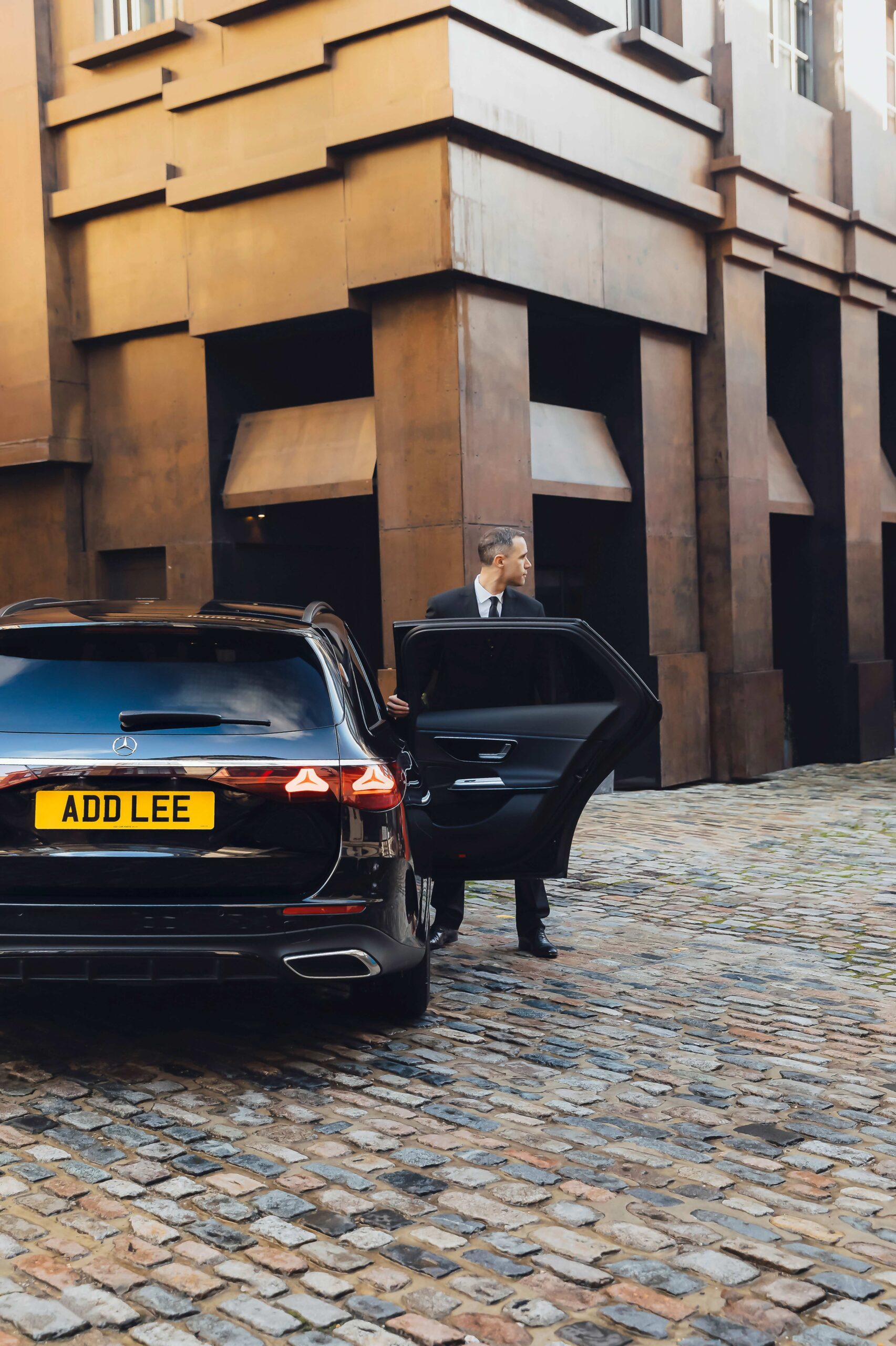 Chauffeur holding car door open