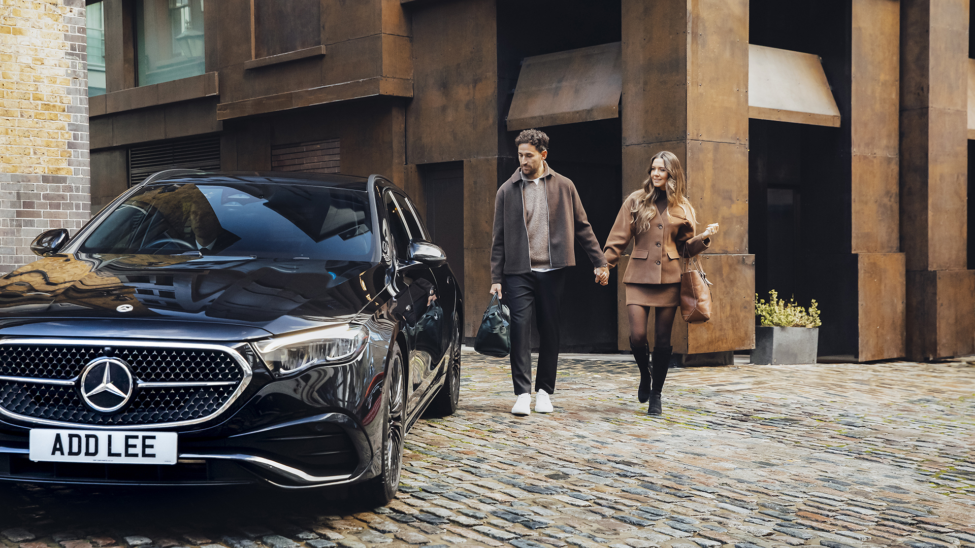 A couple with luggage getting an Addison Lee airport transfer