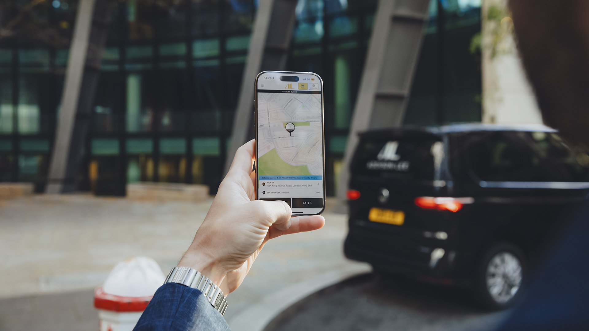 Man holding his phone using the Addison Lee app to book a taxi