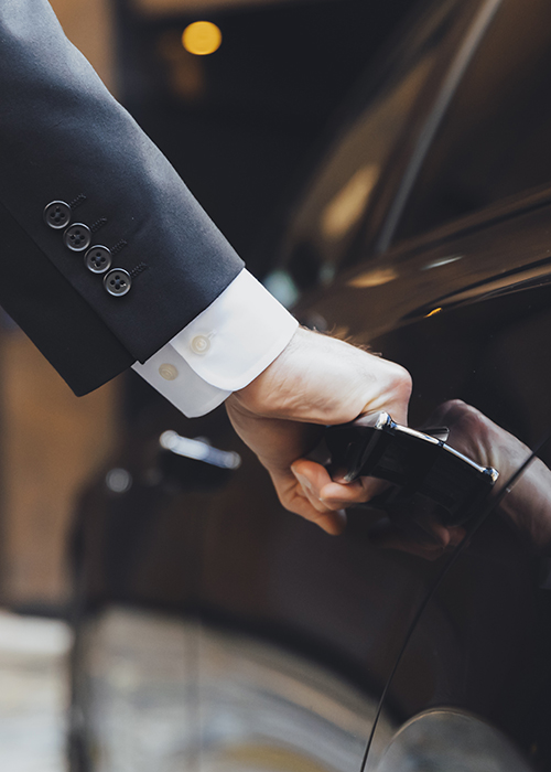 Cropped shot of an Addison Lee chauffeur opening a car door