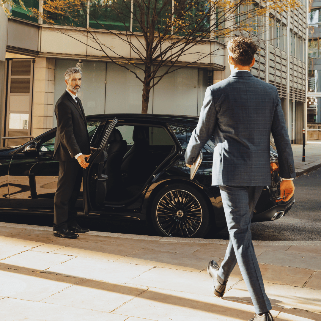 Chauffeur opening door for businessman