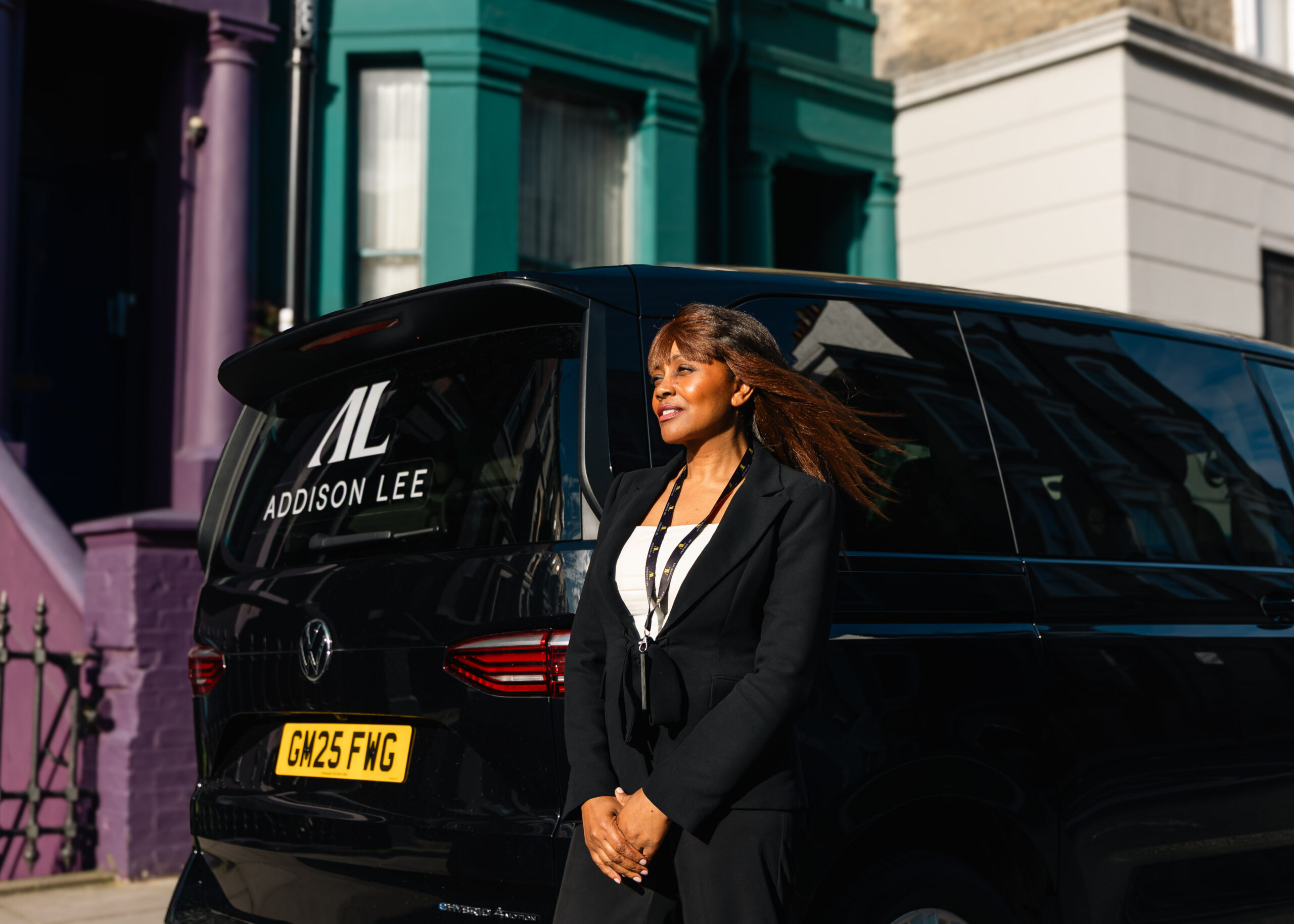 Female driver stood outside addison lee taxi