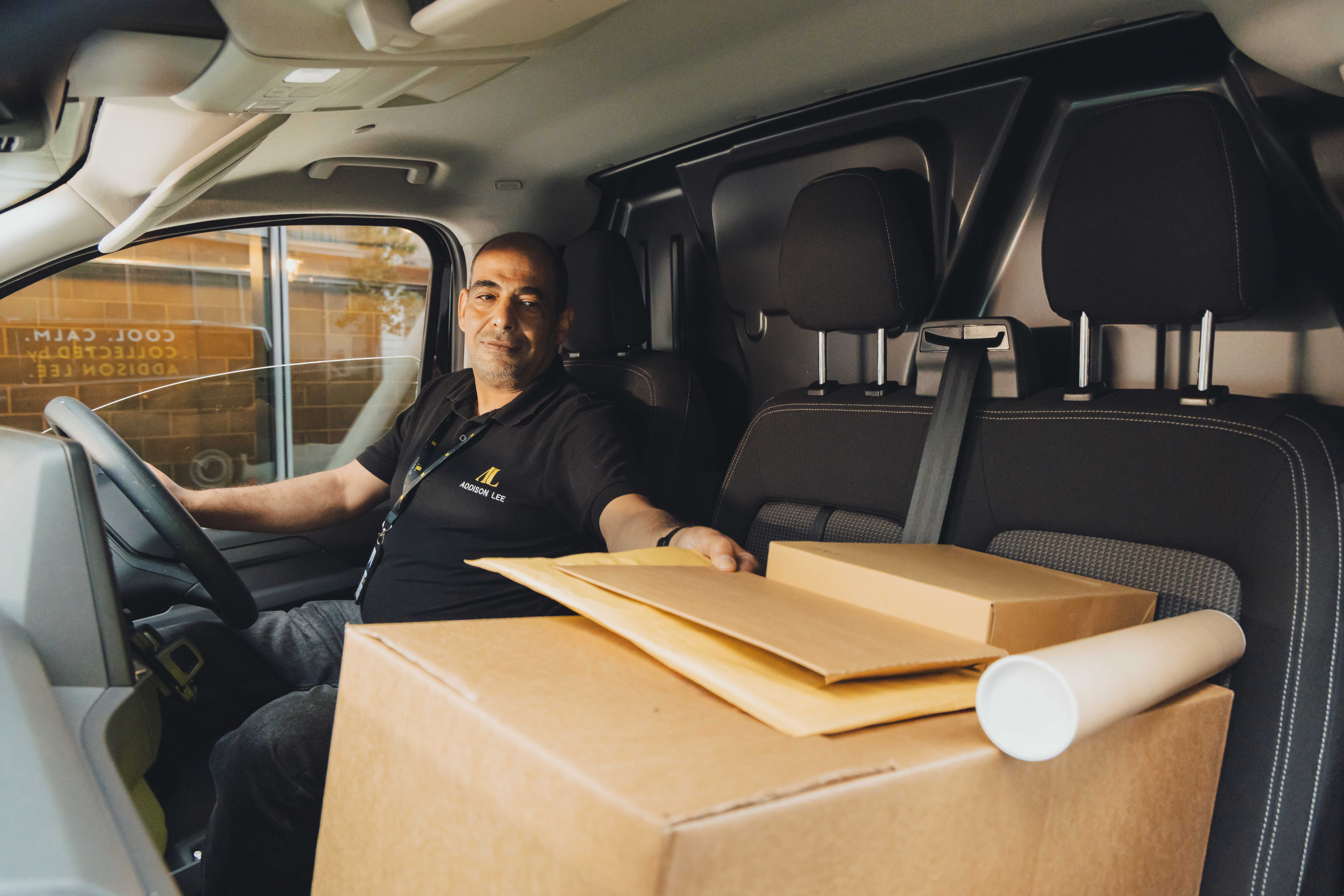Courier delivery driver with lots of parcels in his van