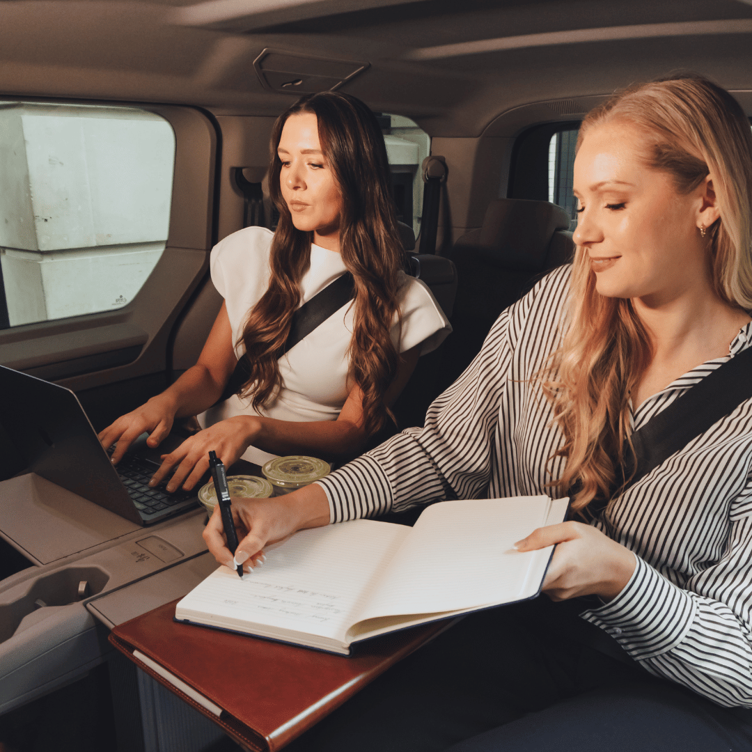 two businesswomen in a multivan having a meeting or doing work