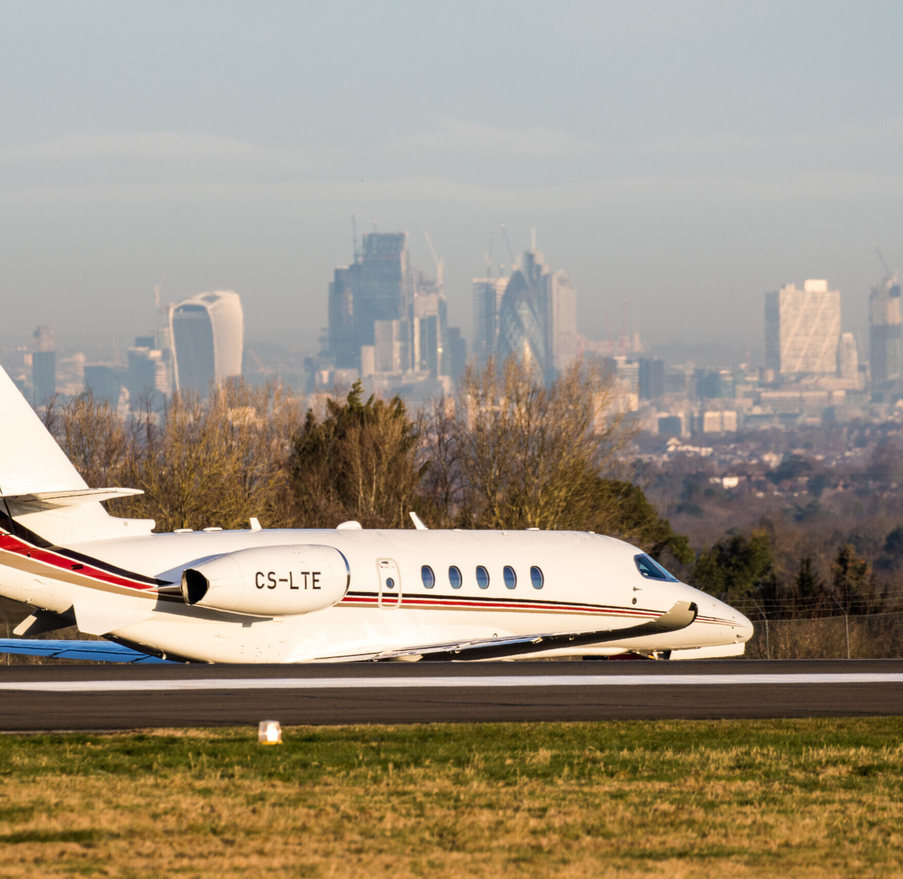 private jet on runway with london in the background