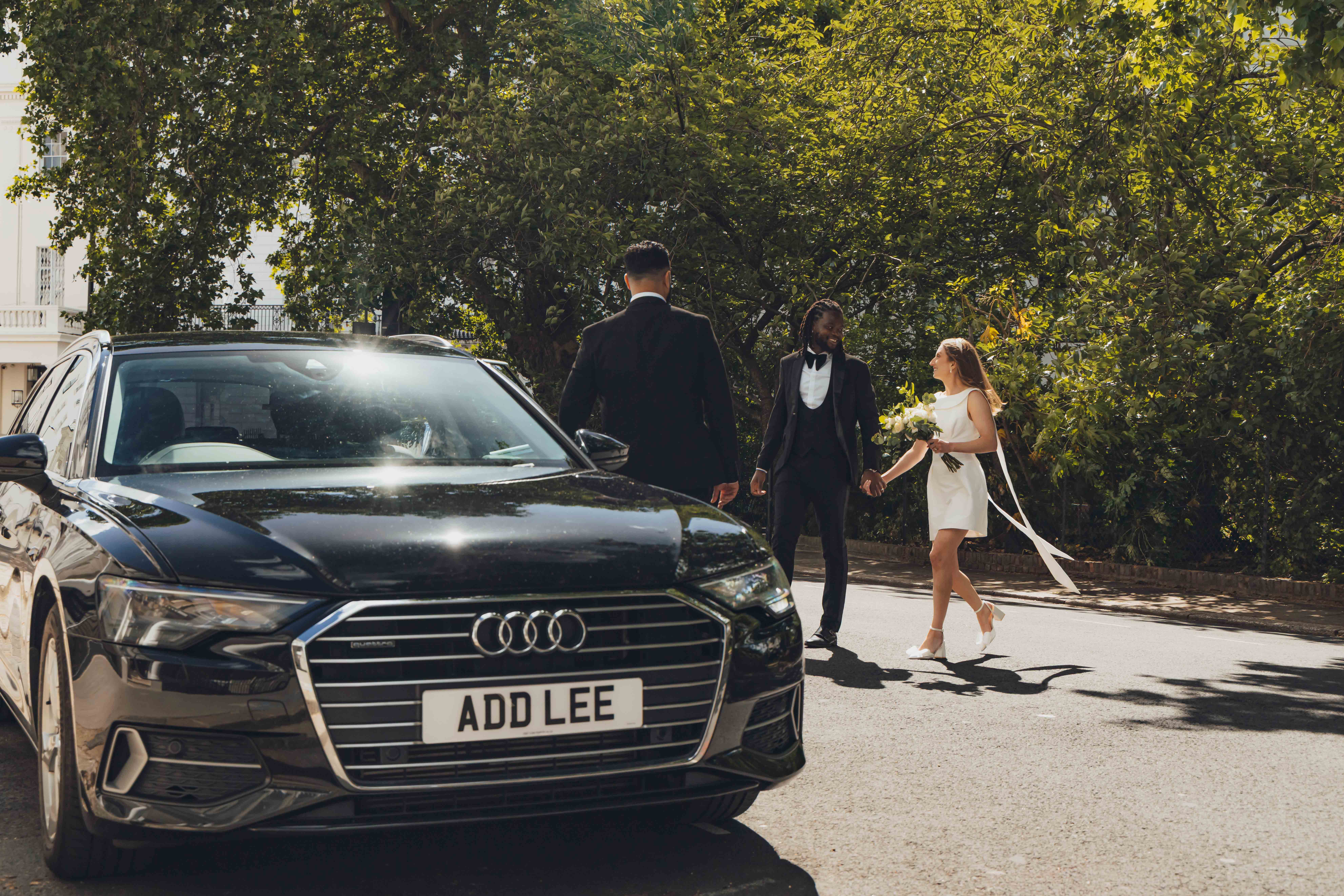 addison lee driver and executive vehicle with bride and groom walking towards booking