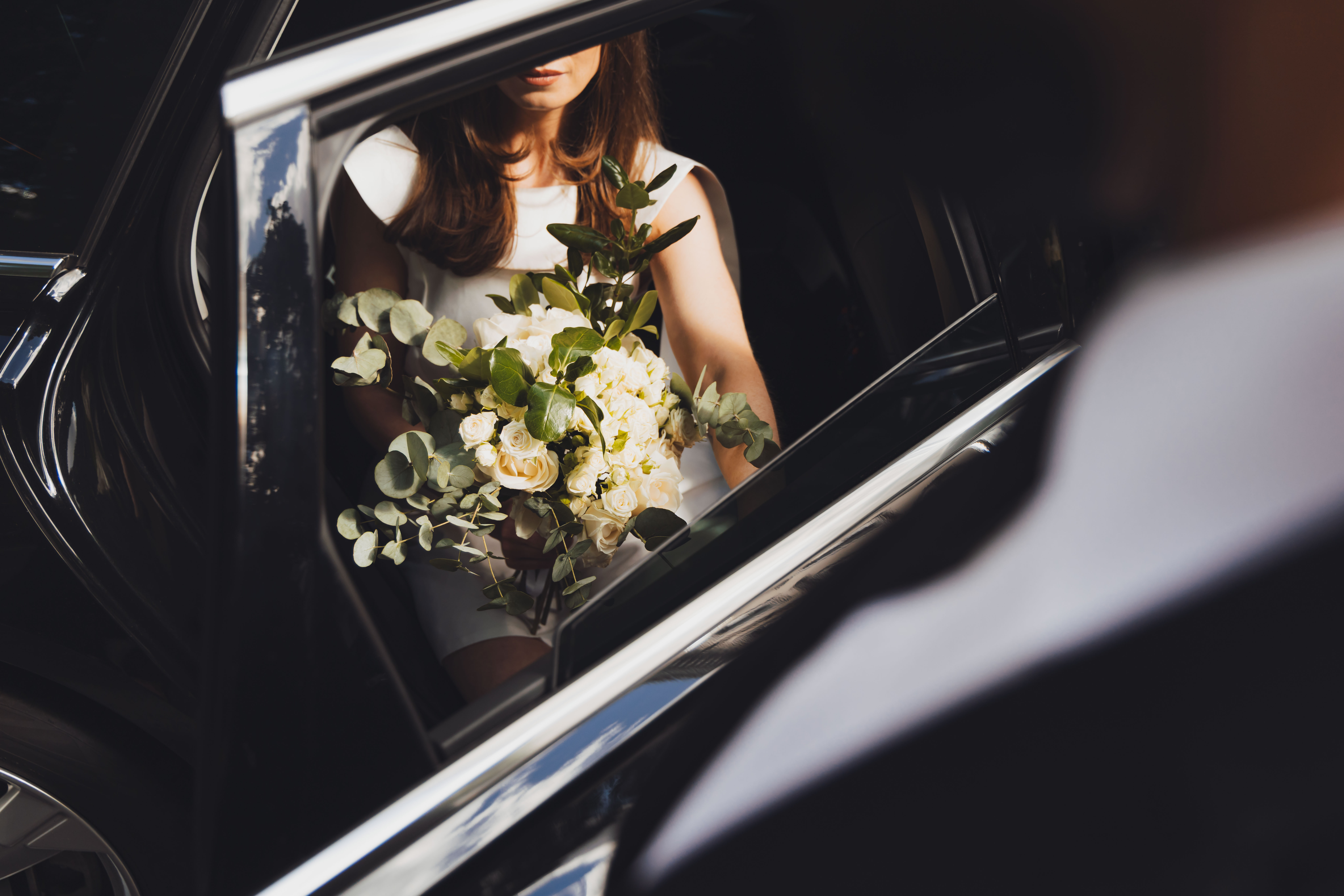 bride with her flowers in the back of an addison lee executive vehicle on the way to her wedding