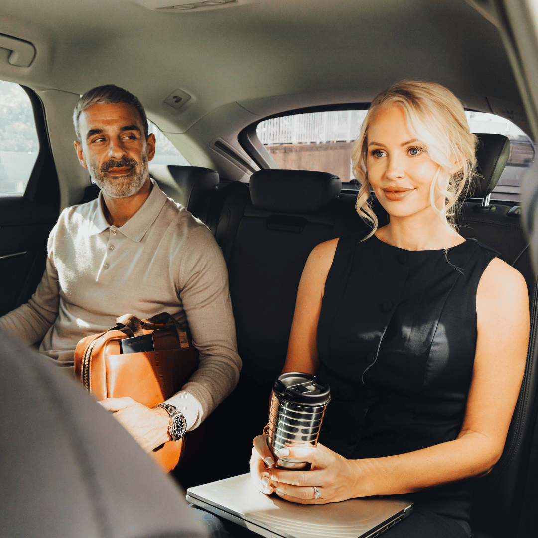 two business people in the back of executive car